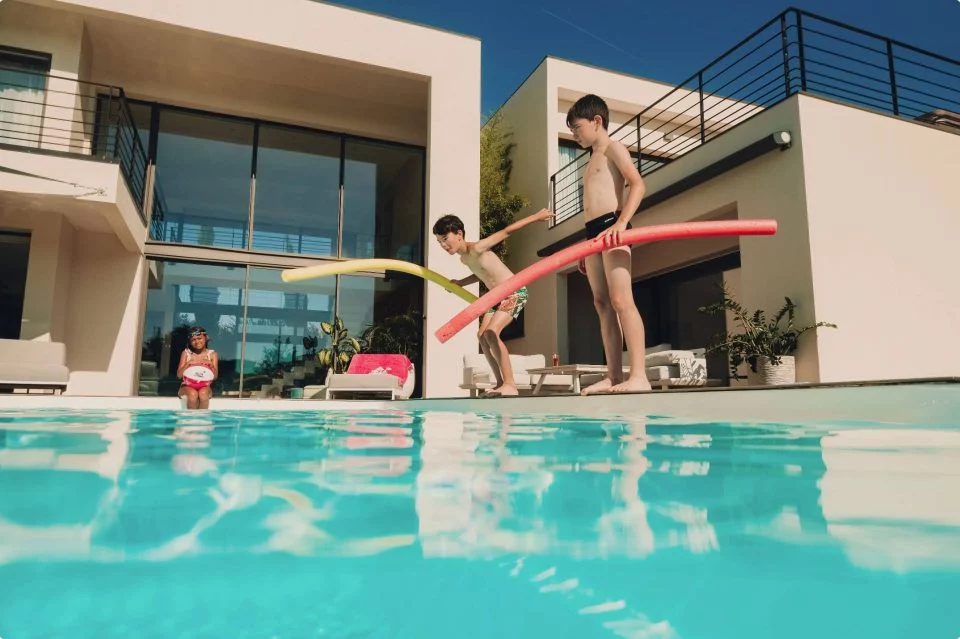 Enfants jouant autour d'une piscine familial